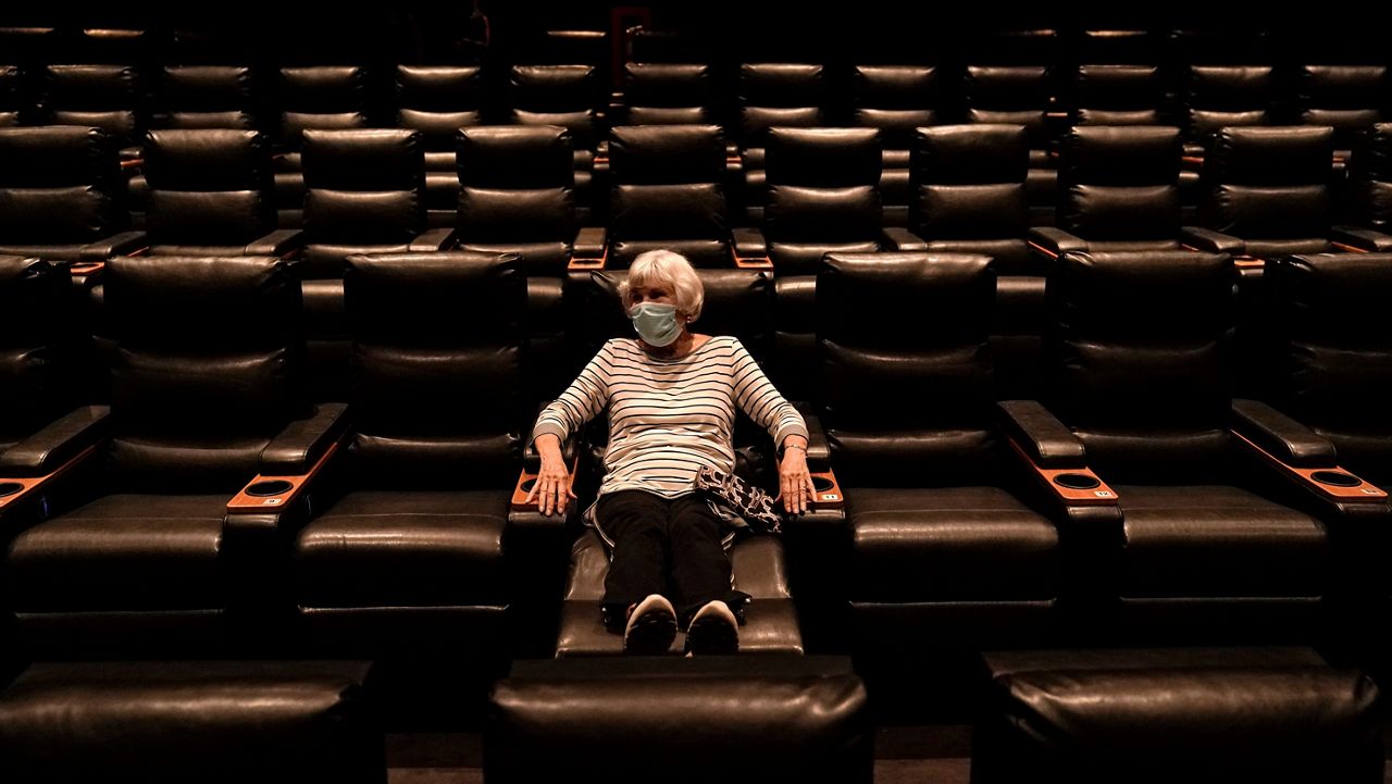 Karen Speros, 82, waits for a movie to start at a Regal movie theater in Irvine, Calif., Tuesday, Sept. 8, 2020, after California Gov. Gavin Newsom relaxed coronavirus restrictions in some counties. (AP Photo/Jae C. Hong)
