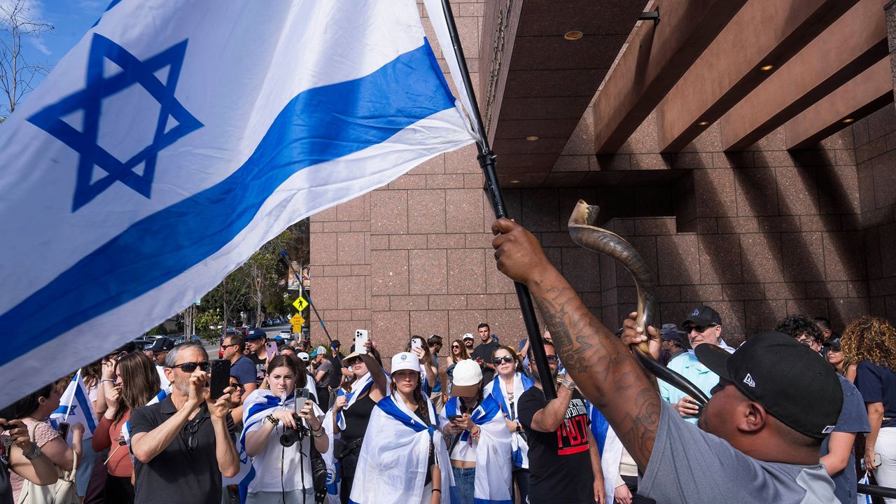 Daniel Chan blows a shofar as he joins pro-Israeli supporters to condemn a violent protest the previous weekend outside Adas Torah synagogue as members of the Jewish community gather at Simon Wiesenthal Center on Monday, June 24, 2024, in Los Angeles. (AP Photo/Damian Dovarganes)