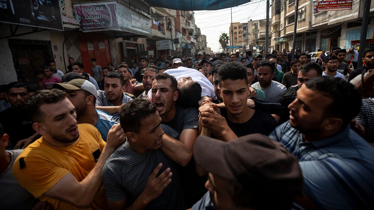 Mourners carry the body of Palestinian Tamim Hijazi, who was killed in an Israeli air strike, during his funeral in Khan Yunis in the southern Gaza Strip, Saturday, Aug. 6, 2022. (AP Photo/Yousef Masoud)