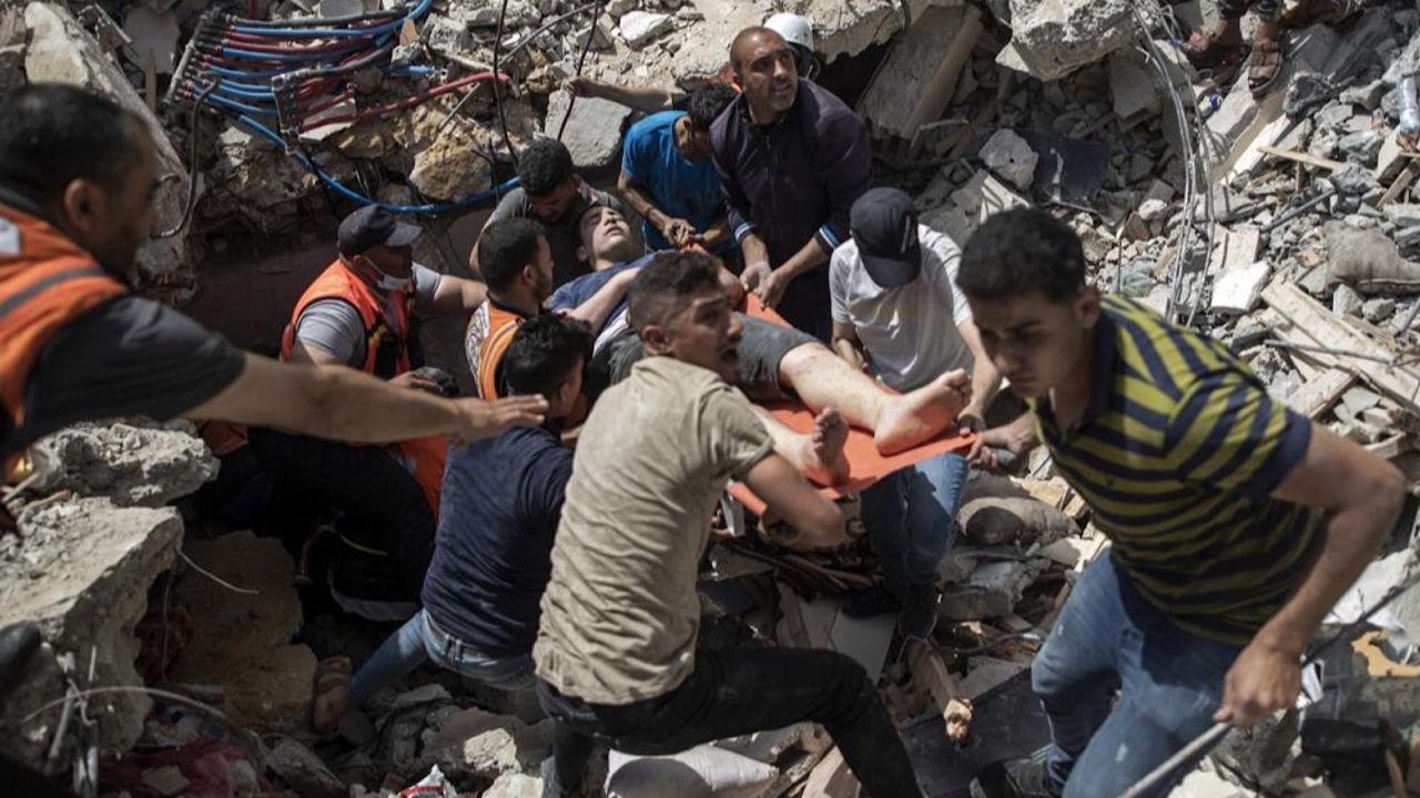 Palestinian rescue a survivor from under the rubble of a destroyed residential building following deadly Israeli airstrikes in Gaza City, Sunday, May 16, 2021. The Israeli airstrikes flattened three buildings and killed at least 26 people Sunday, medics said, making it the deadliest single attack since heavy fighting broke out between Israel and the territory's militant Hamas rulers nearly a week ago. (AP Photo/Khalil Hamra)