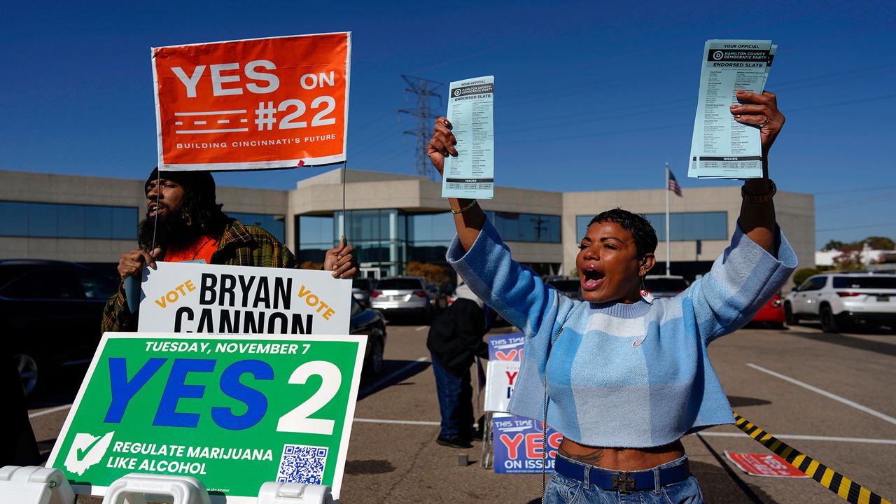 Nikko Griffin, left, and Tyra Patterson, call out to arriving voters in the parking lot of the Hamilton County Board of Elections during early in-person voting in Cincinnati, Thursday, Nov. 2, 2023. (AP Photo/Carolyn Kaster)