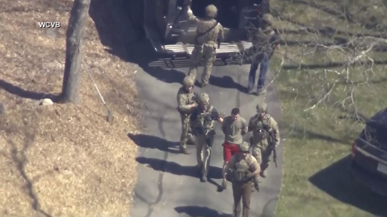 This image made from video provided by WCVB-TV, shows Jack Teixeira, in a T-shirt and shorts, being taken into custody by armed tactical agents on April 13 in Dighton, Mass. (WCVB-TV via AP, File)