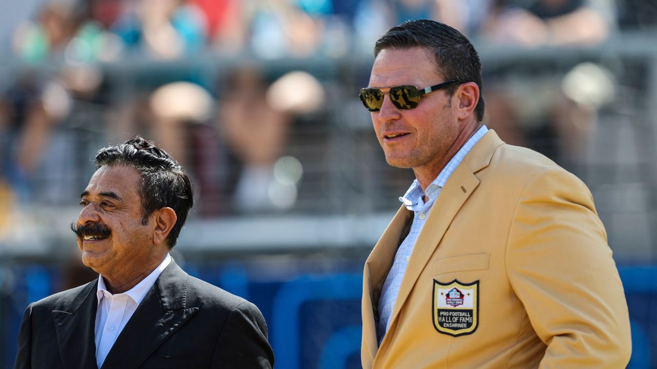 Jacksonville Jaguars owner Shahid Khan, left, stands with Tony Boselli as Boselli waits to receive a Pro Football Hall of Fame ring during halftime of an NFL football game between the Jacksonville Jaguars and the Houston Texans on Sunday, Oct. 9, 2022, in Jacksonville, Fla. (AP Photo/Gary McCullough)