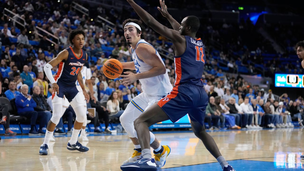 UCLA guard Jaime Jaquez Jr. (24) is defended by Pepperdine forward Boubacar Coulibaly during the second half of an NCAA college basketball game Wednesday, Nov. 23, 2022, in Los Angeles. (AP Photo/Marcio Jose Sanchez)