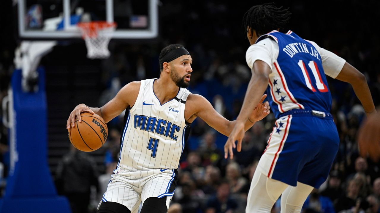 Orlando Magic guard Jalen Suggs (4) is defended by Philadelphia 76ers guard Jeff Dowtin Jr. (11) during the first half of a preseason NBA basketball game, Friday, Oct. 18, 2024, in Orlando, Fla. (AP Photo/Phelan M. Ebenhack)