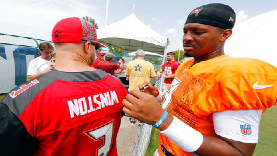 Tampa Bay Buccaneers quarterback Jameis Winston looks at a fan's jersey with his name printed upside down before he autographs it after a combined NFL football training camp practice with the Tennessee Titans Wednesday, Aug. 15, 2018, in Nashville, Tenn. (AP Photo/Mark Humphrey)