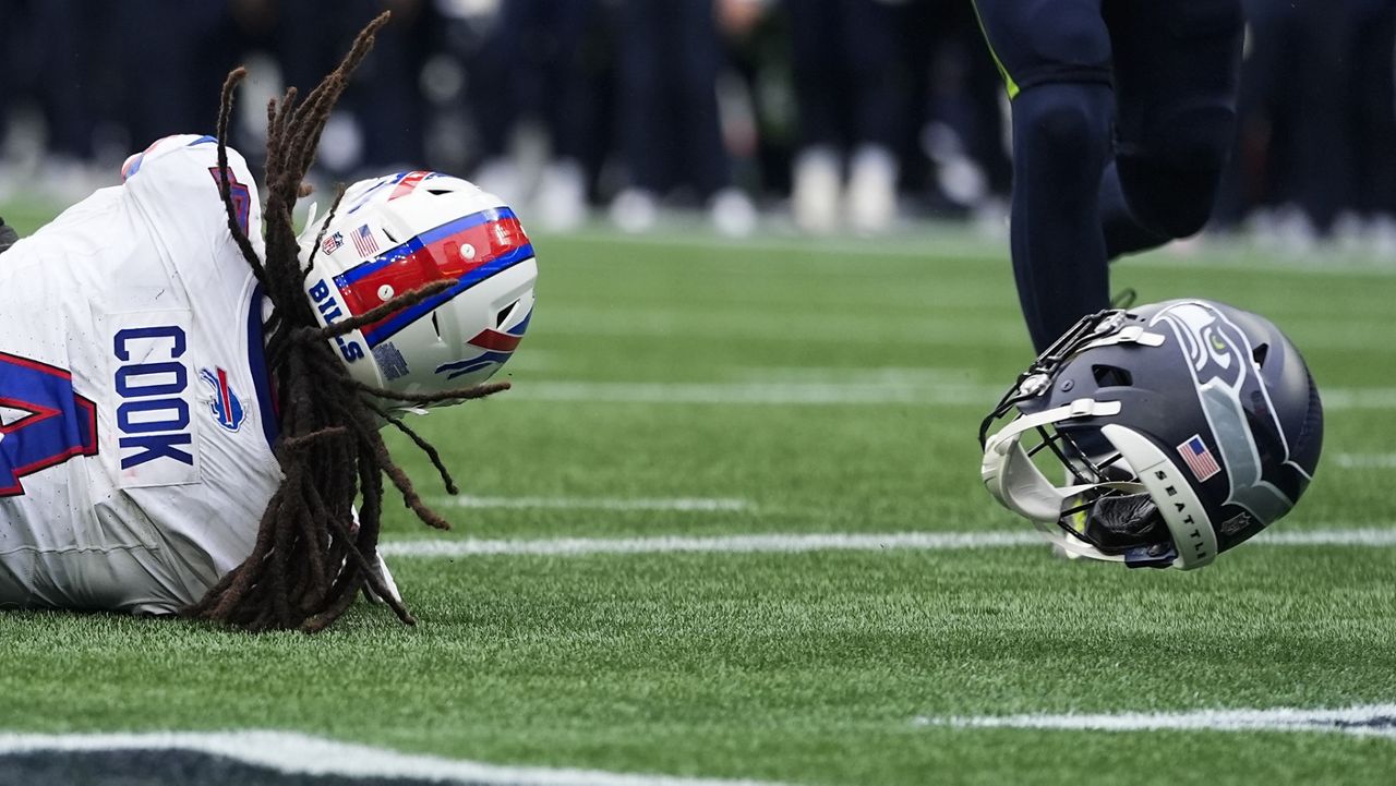 Buffalo Bills running back James Cook (4) scores a touchdown as the helmet of Seattle Seahawks linebacker Ernest Jones IV is seen in the endzone after it came off during the play during the second half of an NFL football game, Sunday, Oct. 27, 2024, in Seattle. (AP Photo/Lindsey Wasson)