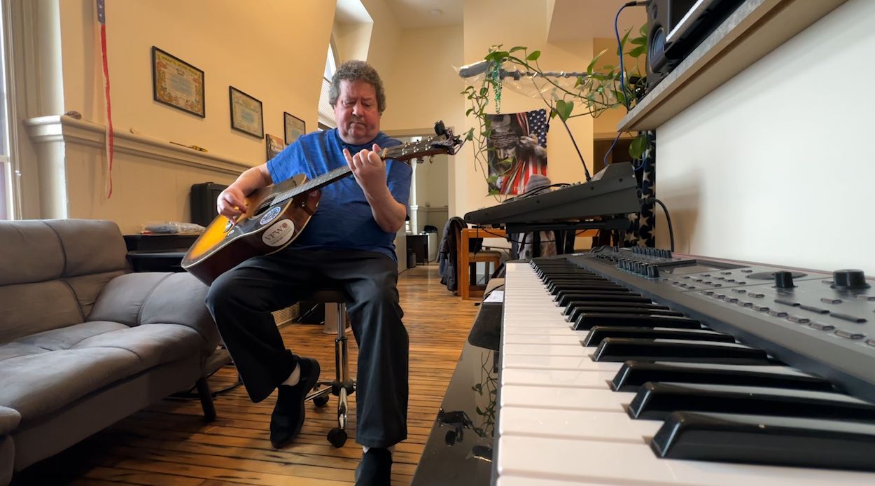 Veteran James Graham plays his guitar in his Soldier's home apartment