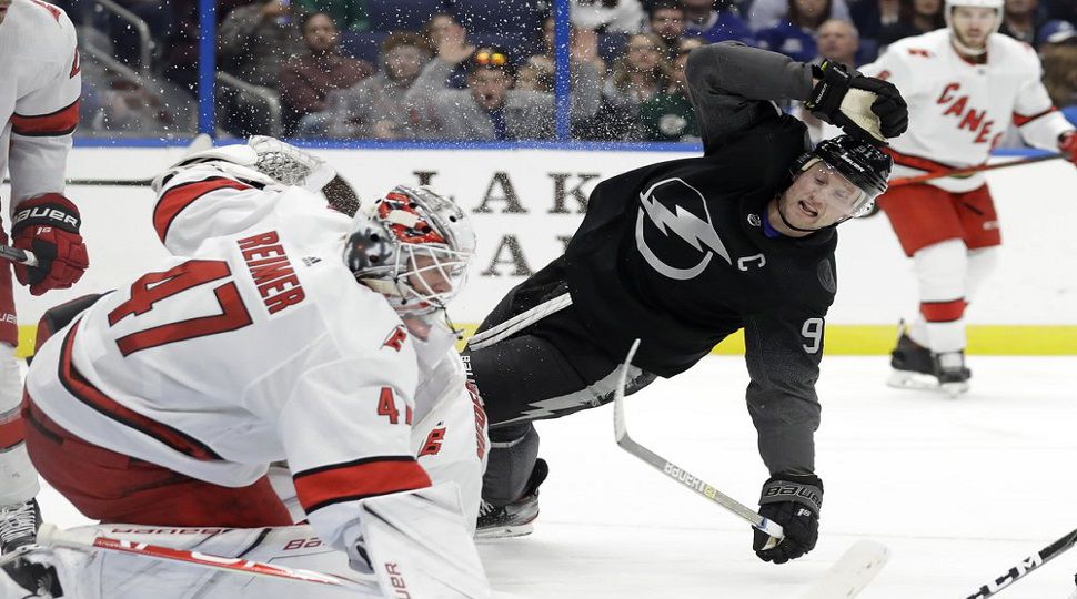 Tampa Bay Lightning center Steven Stamkos (91) goes down after shooting on Carolina Hurricanes goaltender James Reimer (47) during the second period of an NHL hockey game, Saturday, Nov. 30, 2019, in Tampa, Fla. (AP Photo/Chris O'Meara)