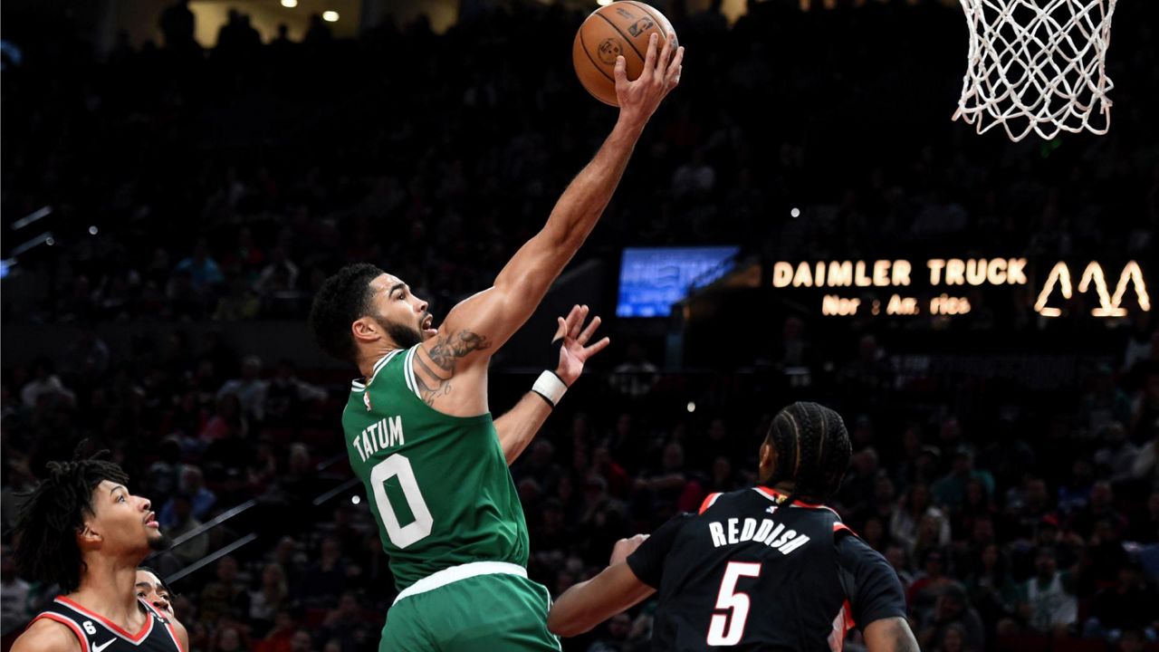 Boston Celtics forward Jayson Tatum, center, drives to the basket against Portland Trail Blazers guard Shaedon Sharpe, left, and forward Cam Reddish, right, during the first half of an NBA basketball game in Portland, Ore., Friday, March 17, 2023. (AP Photo/Steve Dykes)