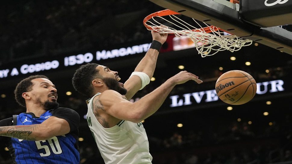 Boston Celtics' Jayson Tatum, right, dunks against Orlando Magic's Cole Anthony (50) during the first half of an NBA basketball game, Friday, Jan. 17, 2025, in Boston. (AP Photo/Robert F. Bukaty)