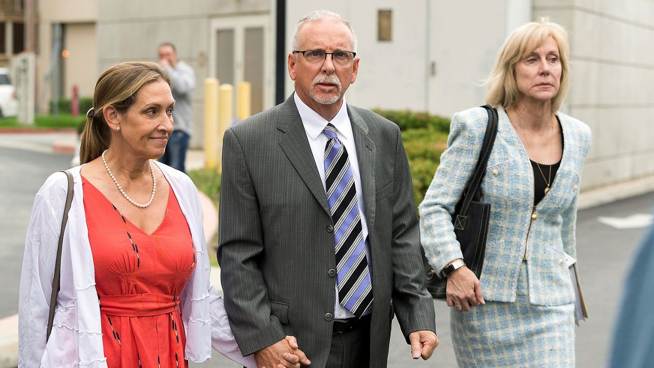 Former UCLA gynecologist Dr. James Heaps, center, with his wife Deborah, left, and defense attorney Tracy Green leave Los Angeles Superior Court, on June 26, 2019. (AP Photo/Damian Dovarganes, File)