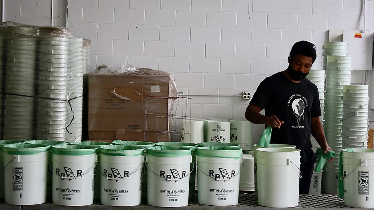 worker lines food recycling bins  