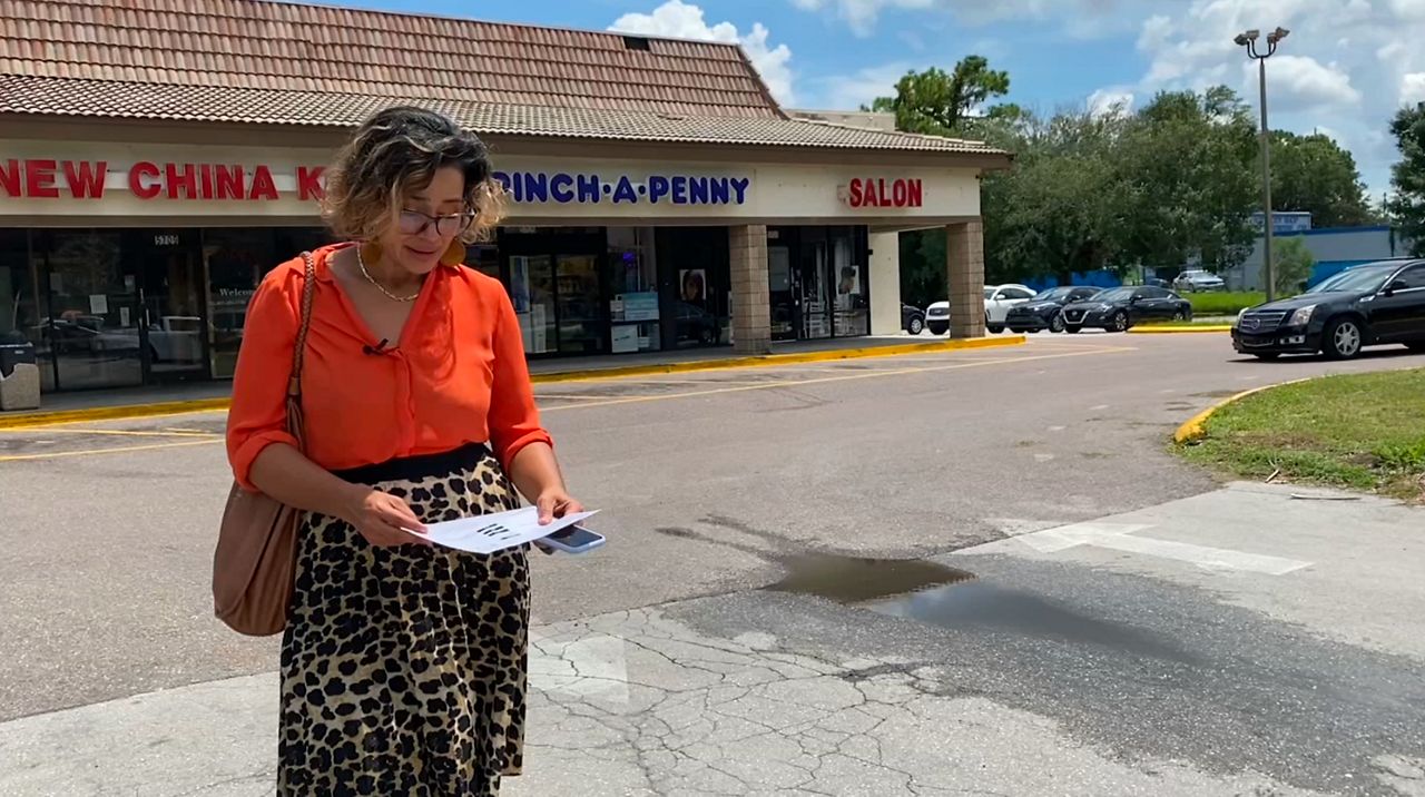 Orange County renter Jessy Correa looks at a paper detailing problems with her family's only working vehicle. Her monthly rent recently went up by $300, and she says she's facing an additional increase of 17% if she chooses to renew her lease. (Spectrum News/Molly Duerig)