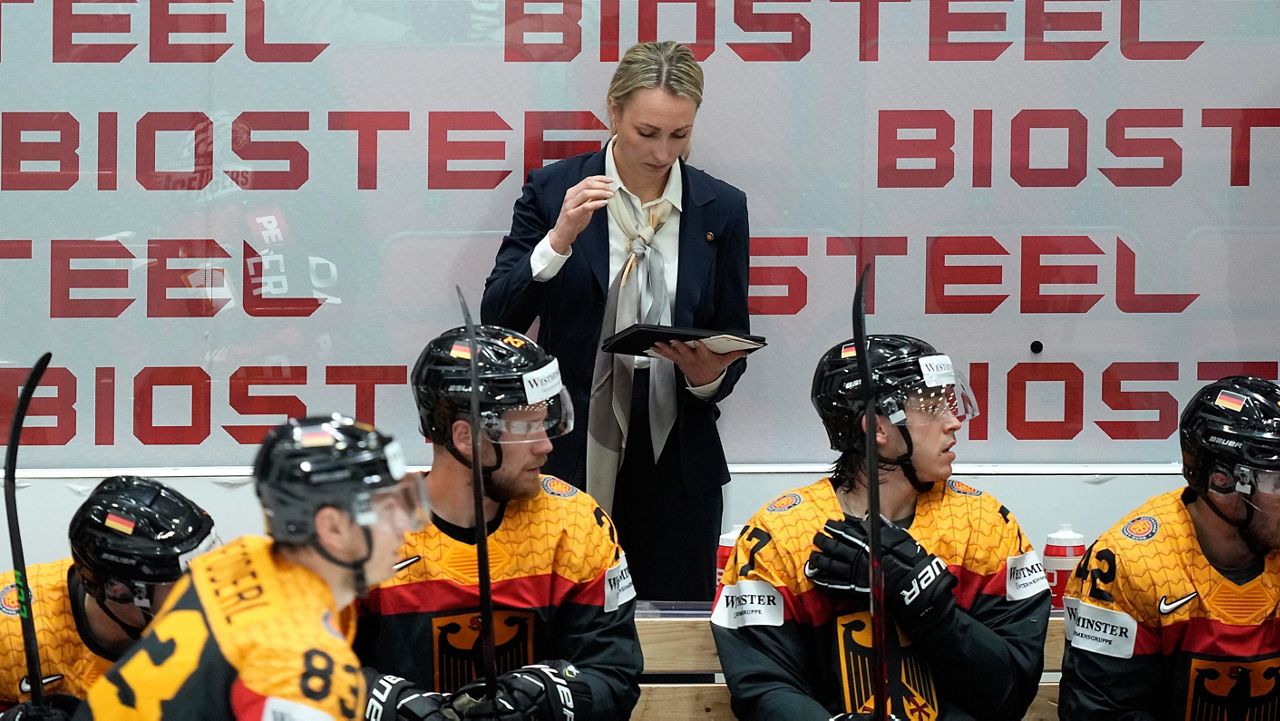 Germany's assistant coach Jessica Campbell watches a screen behind players at the German bench during the group A Hockey World Championship match between France and Germany in Helsinki, Finland, Monday May 16, 2022. (AP Photo/Martin Meissner)