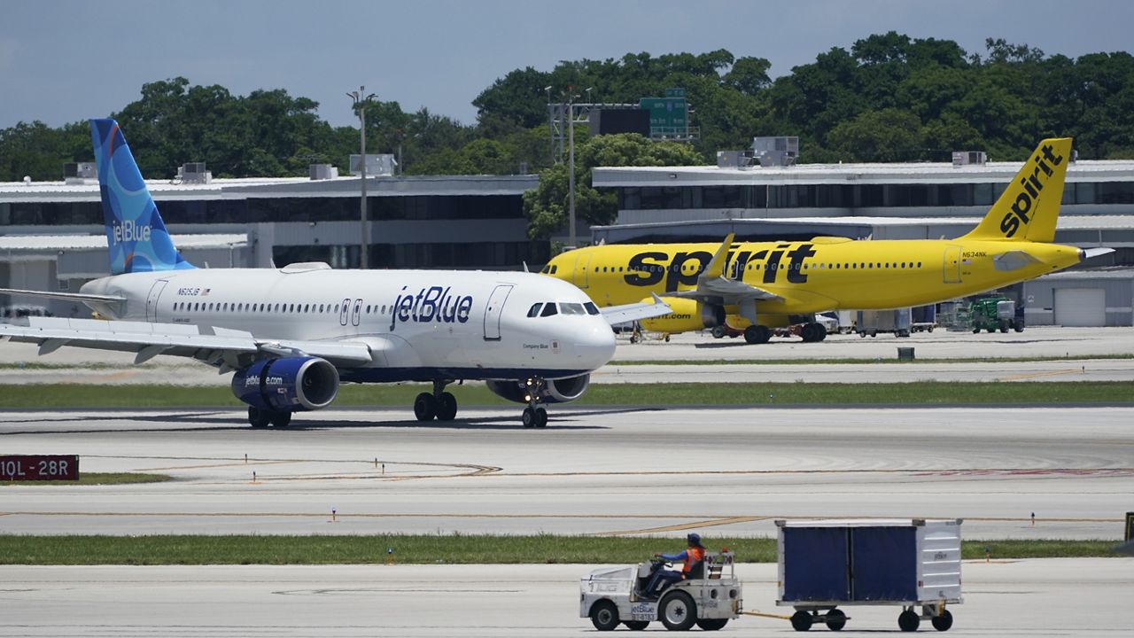 A JetBlue Airways Airbus A320, left, passes a Spirit Airlines Airbus A320 as it taxis on the runway, July 7, 2022, at the Fort Lauderdale-Hollywood International Airport in Fort Lauderdale, Fla. (AP Photo/Wilfredo Lee)