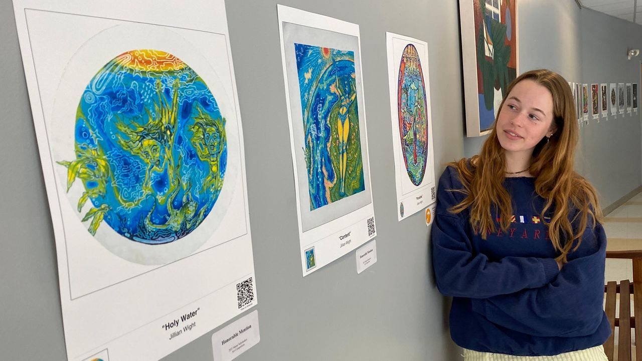 Jillian Wight, 17, a senior at Freeport High School, with some of her works being entered into a statewide art competition. WIght's drawing, "Family Room," has been selected to represent Maine's first congressional district in a display in Washington, DC. (Spectrum News/Sean Murphy)