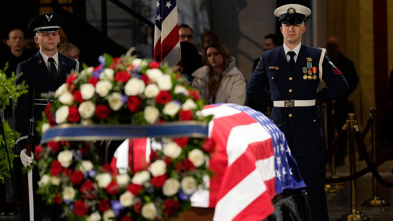 Honor guards pay their respects as the flag-draped casket of former President Jimmy Carter lies in state at the U.S. Capitol, Wednesday, Jan. 8, 2025, in Washington. Carter died Dec. 29 at the age of 100. (AP Photo/Steve Helber)