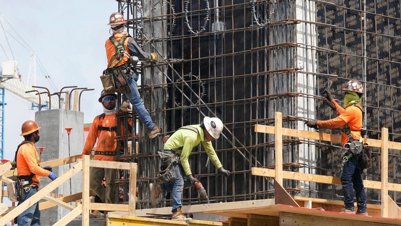 Construction workers fasten the frame of a new building May 3 in Miami. (AP Photo/Marta Lavandier, File)