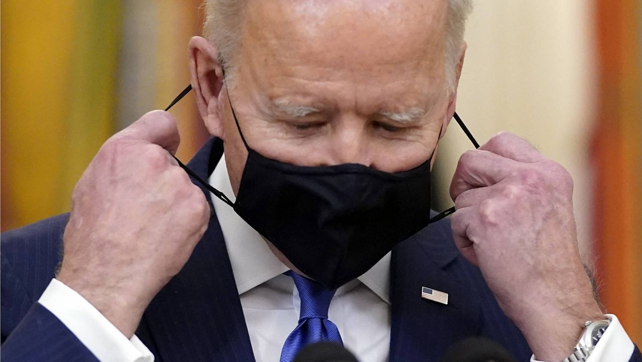 President Joe Biden takes his face mask off before speaking at a White House event Monday. (AP Photo/Patrick Semansky)