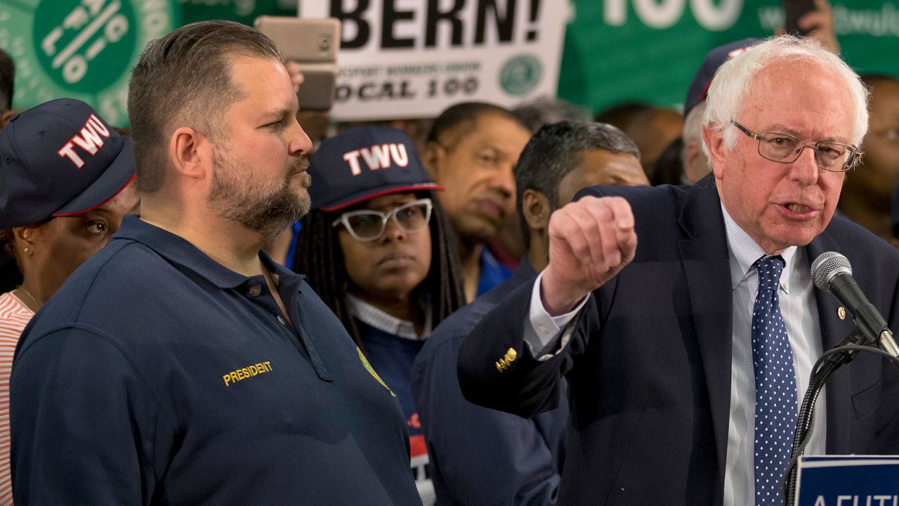 TWU Local 100 President John Samuelsen listens at left as Democratic presidential candidate, Sen. Bernie Sanders, I-Vt. speaks in Brooklyn in April 2016. On Monday, the now international boss of the Transport Workers Union of America was named to the board tasked with setting congestion pricing tolls by Mayor Eric Adams. (AP Photo/Mary Altaffer)