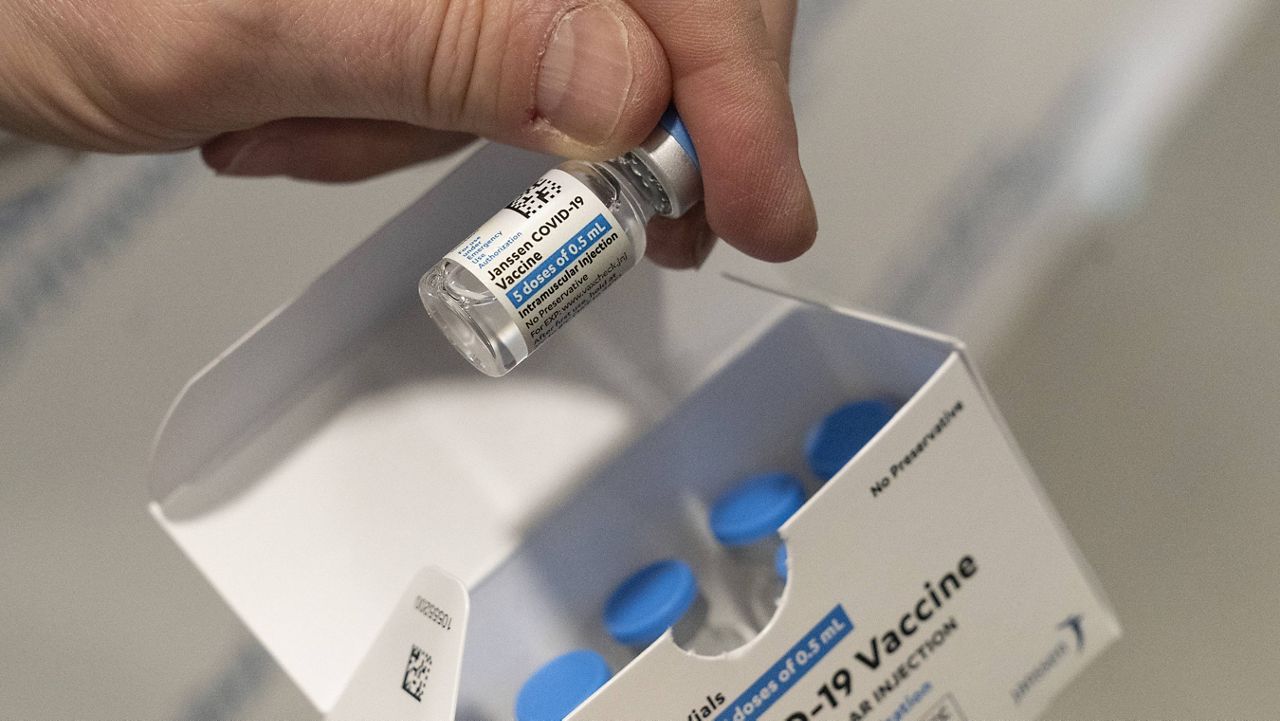 A pharmacist holds a vial of the Johnson & Johnson COVID-19 vaccine. (AP Photo/Mark Lennihan, File)