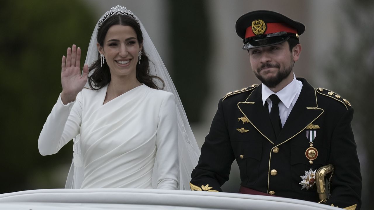 Jordan's Crown Prince Hussein and Saudi Rajwa Alseif wave Thursday to well-wishers during their wedding ceremony in Amman, Jordan. (AP Photo/Nasser Nasser)