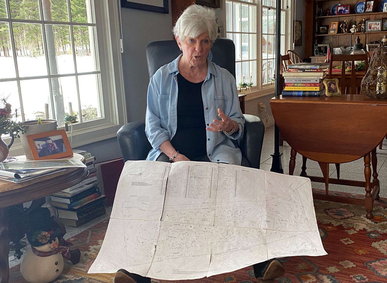 Joyce Foley, in her Limington home, shows a map of Cedar Brook Burial Ground, a private cemetery located on her property. The cemetery allows for "green burials," or internments without the use of harsh chemicals, toxic metals or other contaminants. (Sean Murphy / Spectrum News)