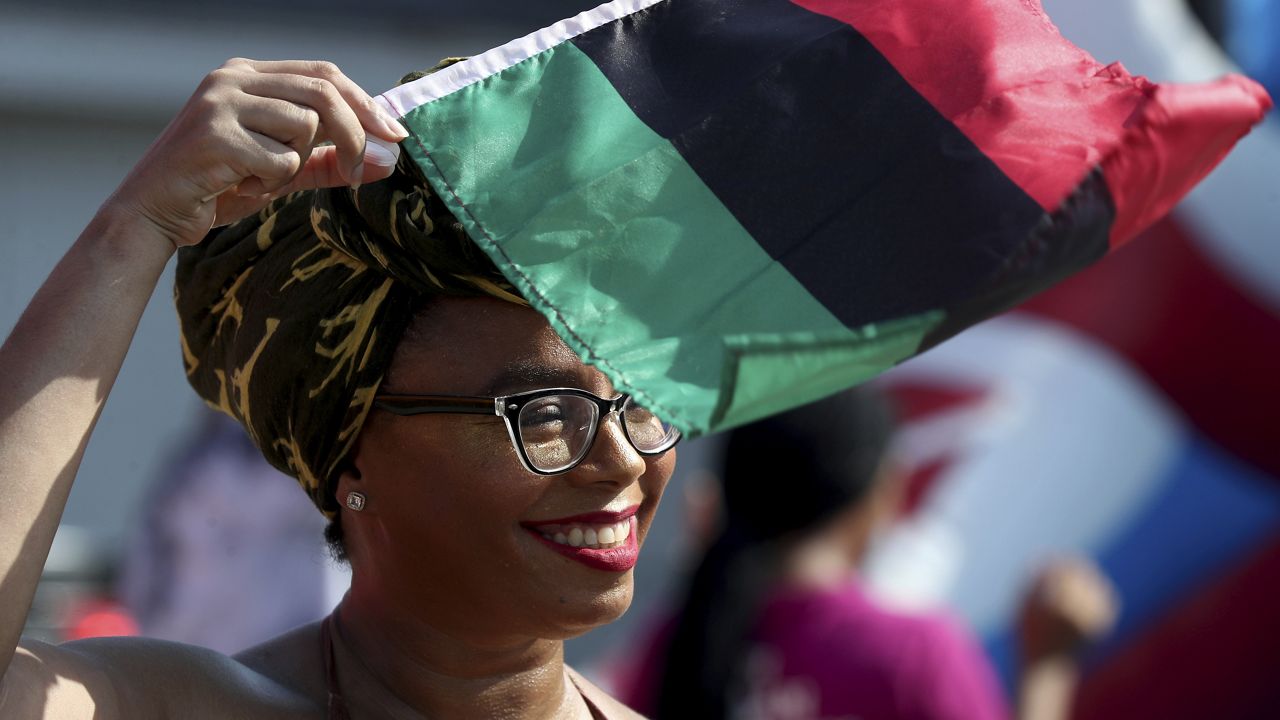 Crystal Baziel holds the Pan-African flag Monday, June 19, 2023, during Reedy Chapel A.M.E Church's annual Juneteenth Family Fun Day, in Galveston, Texas. (Jennifer Reynolds/The Galveston County Daily News via AP, File)