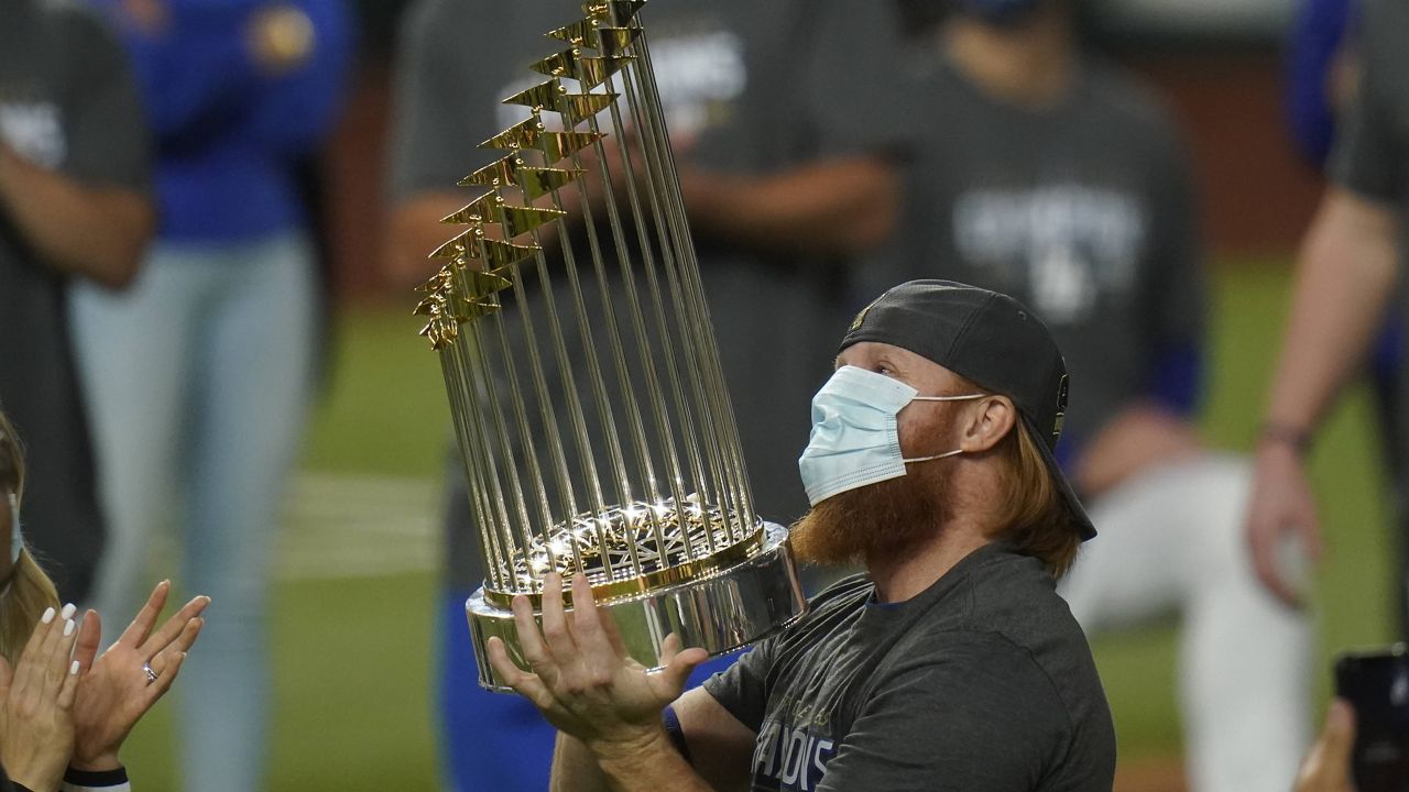 Justin Turner celebrates with the trophy after the Dodgers defeated the Tampa Bay Rays 3-1 to win the World Series on Tuesday night. (AP Photo/Eric Gay)