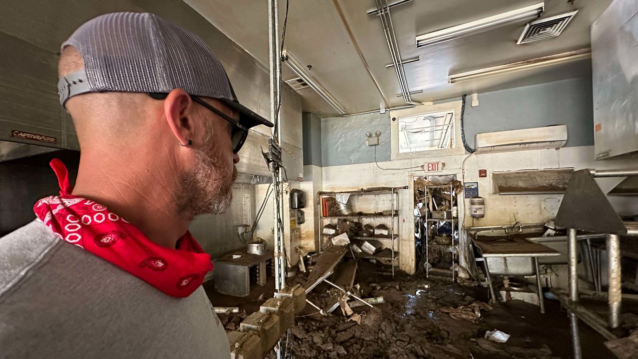 Justin Walton, assistant project manager for Falcon Construction, looks at the damage to a restaurant in the Biltmore Village area. His crew is working on cleaning the building. (Spectrum News 1/Devin Martin)