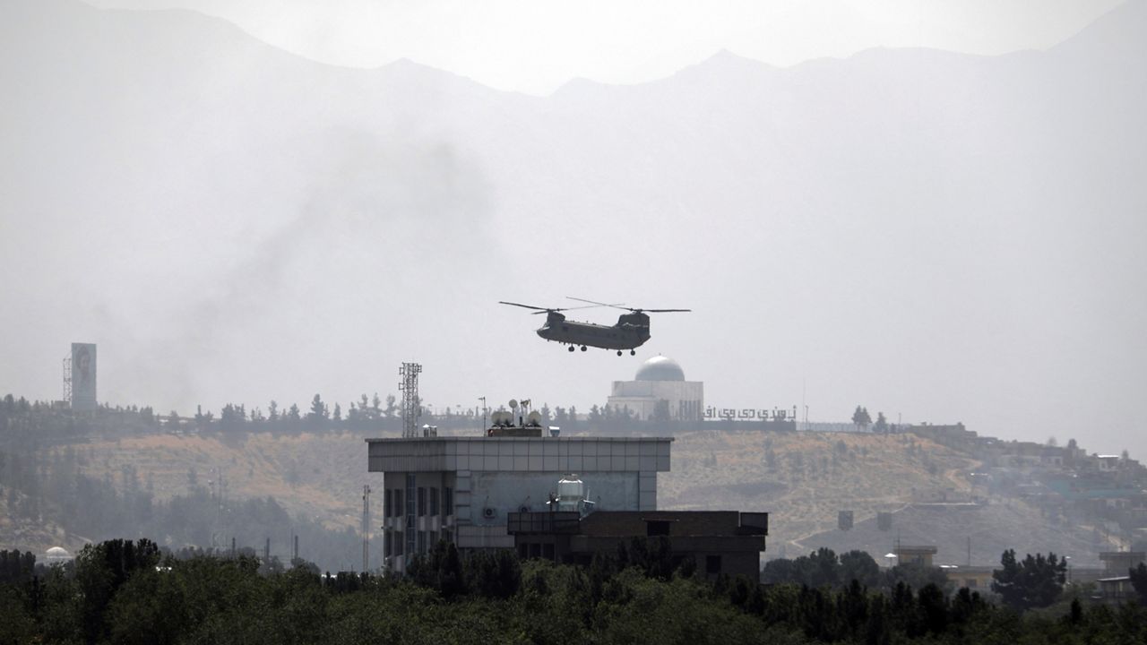 A U.S. Chinook helicopter flies over the U.S. Embassy in Kabul, Afghanistan, Sunday, Aug. 15, 2021. (AP Photo/Rahmat Gul)