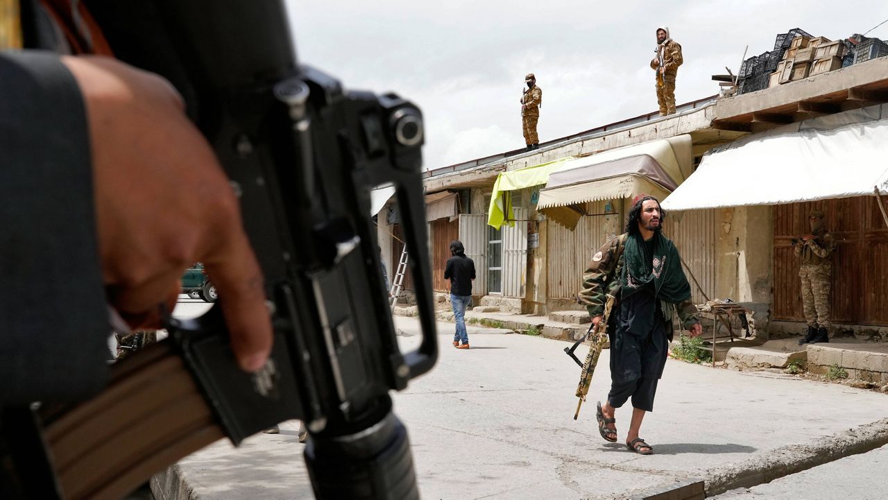 Taliban fighters stand guard Tuesday at the site of an explosion in front of a school in Kabul, Afghanistan. (AP Photo/Ebrahim Noroozi)