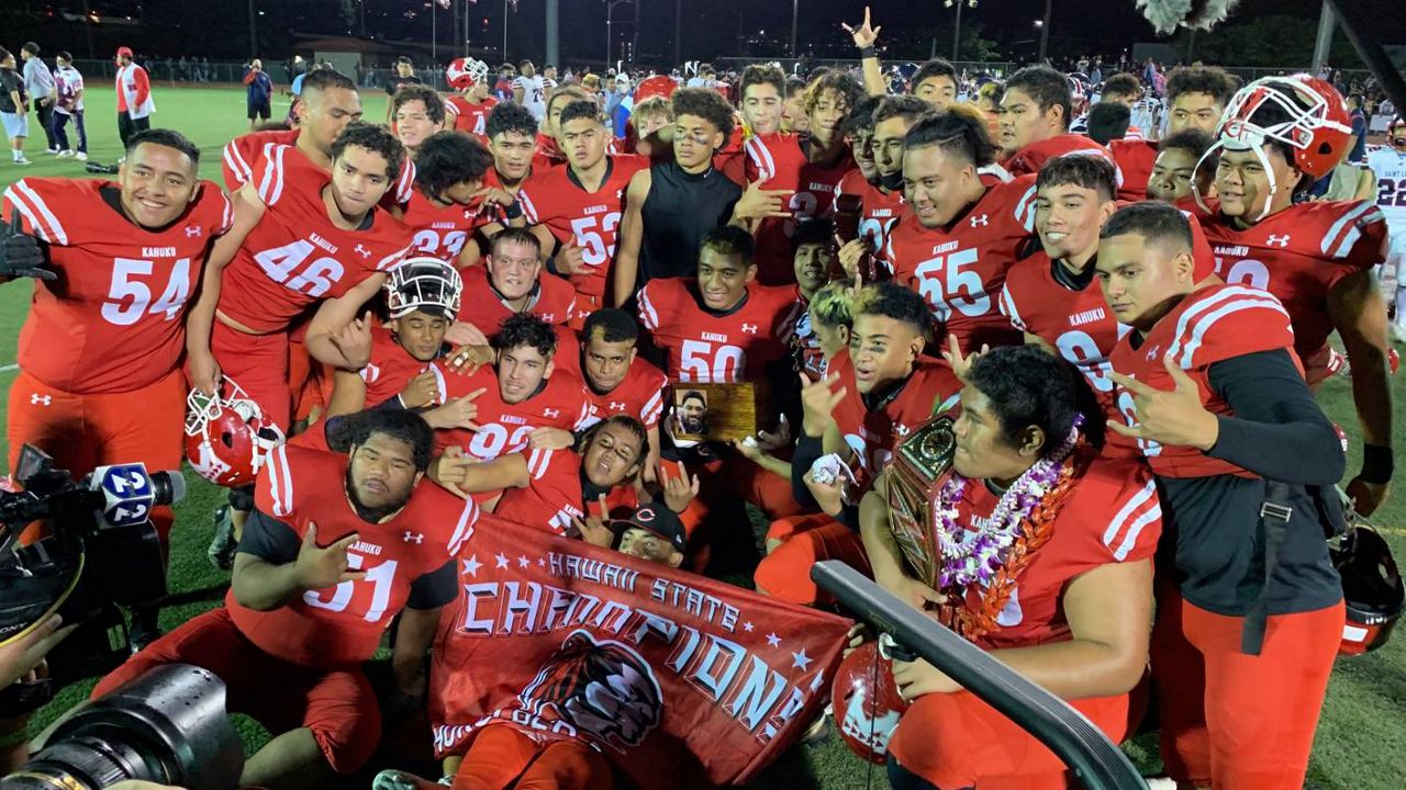 Kahuku players gathered around their HHSAA Open Division trophy after beating Saint Louis 49-14 on Thursday night.