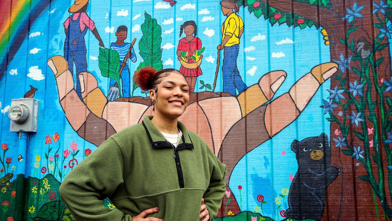 Kailani Taylor-Cribb stands in front of mural at a neighborhood community garden in Asheville, N.C., on Tuesday, Jan. 31, 2023. She knows, looking back, that things could have been different. While she has no regrets about leaving high school, she says she might have changed her mind if someone at school had shown more interest and personal attention to her needs. “All they had to do was take action,” she said. “There were so many times they could have done something. And they did nothing.” (AP Photo/Kathy Kmonicek)