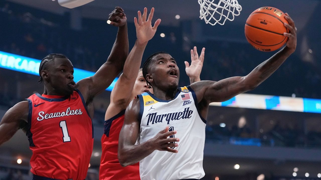 Marquette's Kam Jones shoots past Stony Brook's Sabry Philip and Nick Woodard 