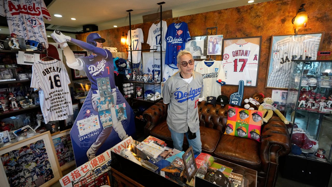 Hironobu Kanno, representative of a private fan club of Shohei Ohtani of the Los Angeles Dodgers, shows his collection items at his beauty salon in Oshu, northeastern Japan, the hometown of Ohtani, on Tuesday. (AP Photo/Eugene Hoshiko)