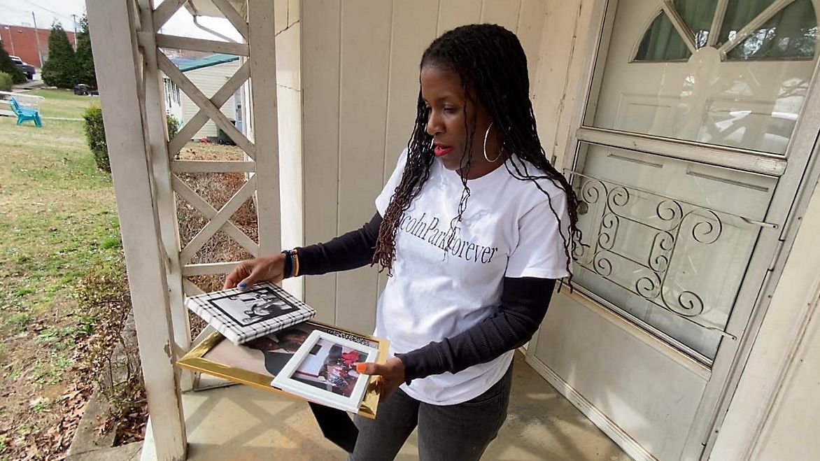 Kassaundra Lockhart looks at old photos on the porch of her grandparents' house in the Lincoln Park neighborhood of Lexington. (Spectrum News 1/Zyneria Byrd)