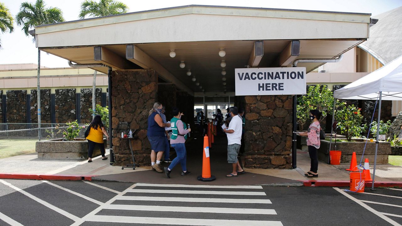 People line up to get COVID-19 vaccinations in Lihue, Hawaii, Wednesday, March 3, 2021. (AP Photo/Caleb Jones)