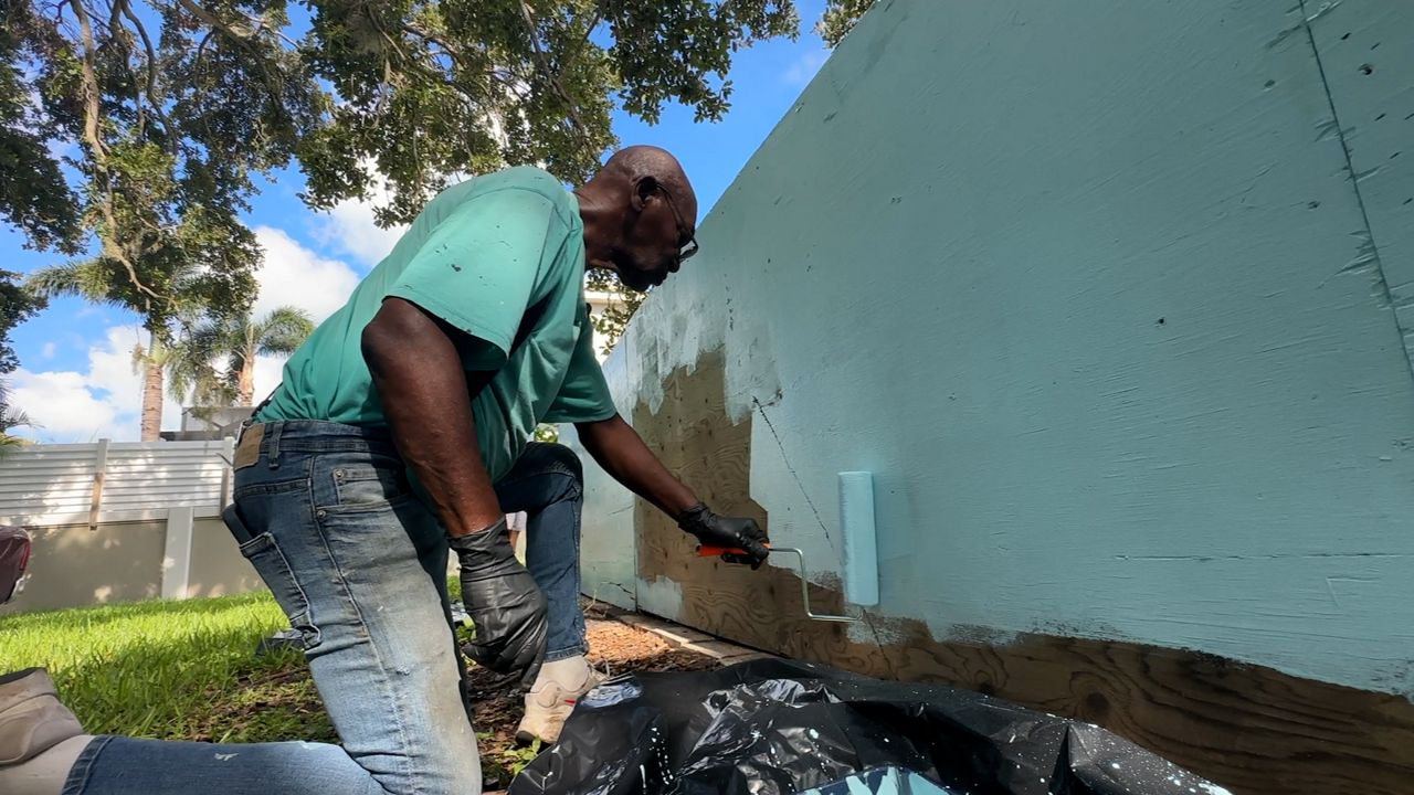 2025 Service Year Alums Awardee Keith Smith painting a fence for a Pinellas County church. (Spectrum News)
