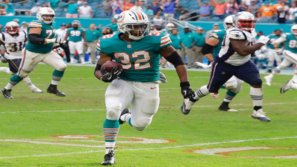 Miami Dolphins running back Kenyan Drake (32) runs for a touchdown during the second half of an NFL football game against the New England Patriots, Sunday, Dec. 9, 2018, in Miami Gardens, Fla. The Dolphins defeated the Patriots 34-33. (AP Photo/Lynne Sladky)