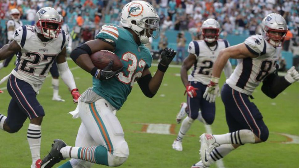 Miami Dolphins running back Kenyan Drake (32) runs for a touchdown during the second half of an NFL football game against the New England Patriots, Sunday, Dec. 9, 2018, in Miami Gardens, Fla. The Dolphins defeated the Patriots 34-33. (AP Photo/Lynne Sladky)