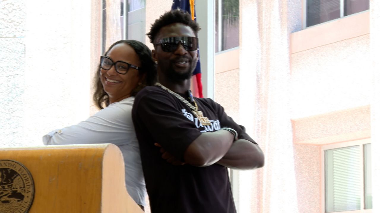 Orlando District 5 Interim Commissioner Shan Rose (left) and Detroit Lions safety Kerby Joseph (right) posing for a picture inside Orlando city hall. 