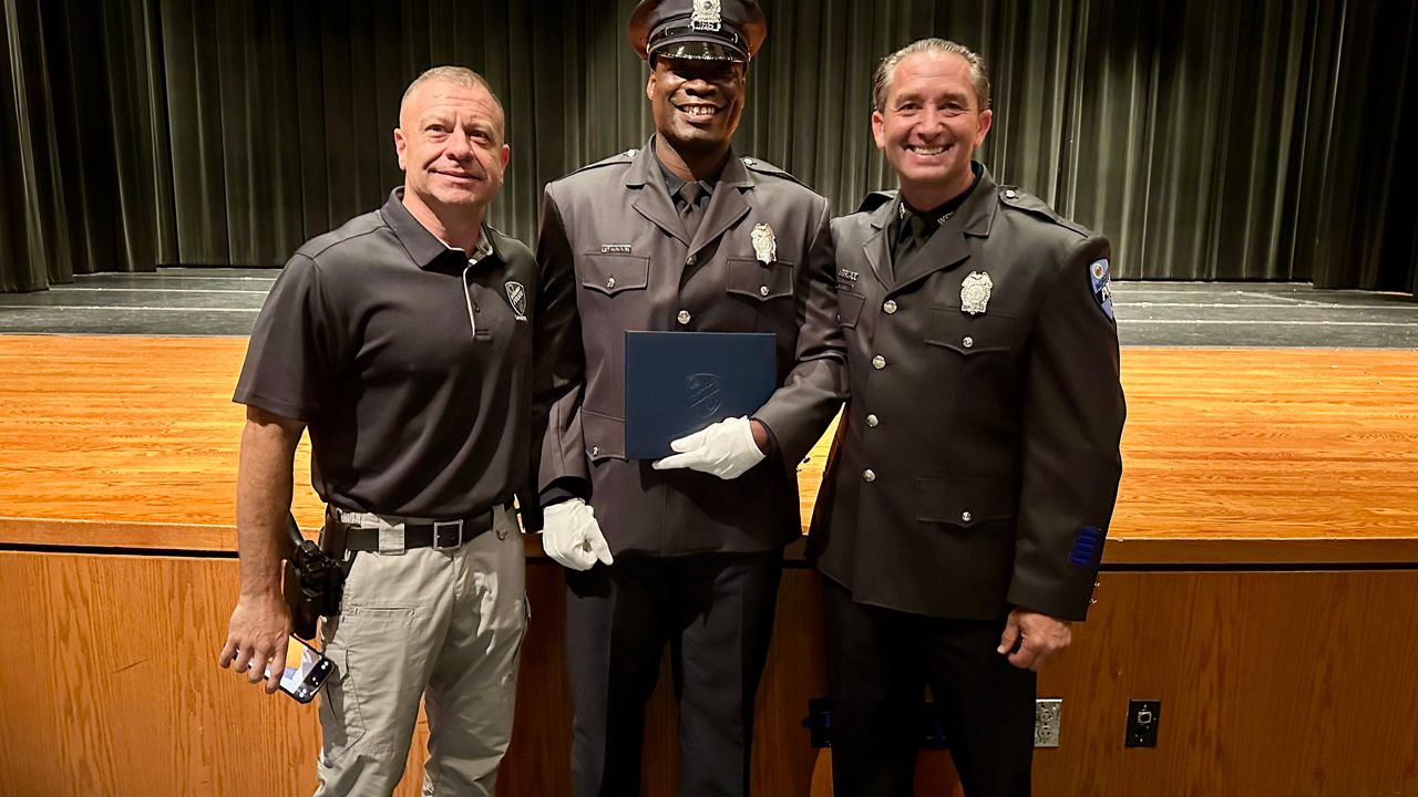 Demek Edmonds (center) with WPD's Tom Duffy and Nate Reando (Spectrum News1/Kevin Shea)