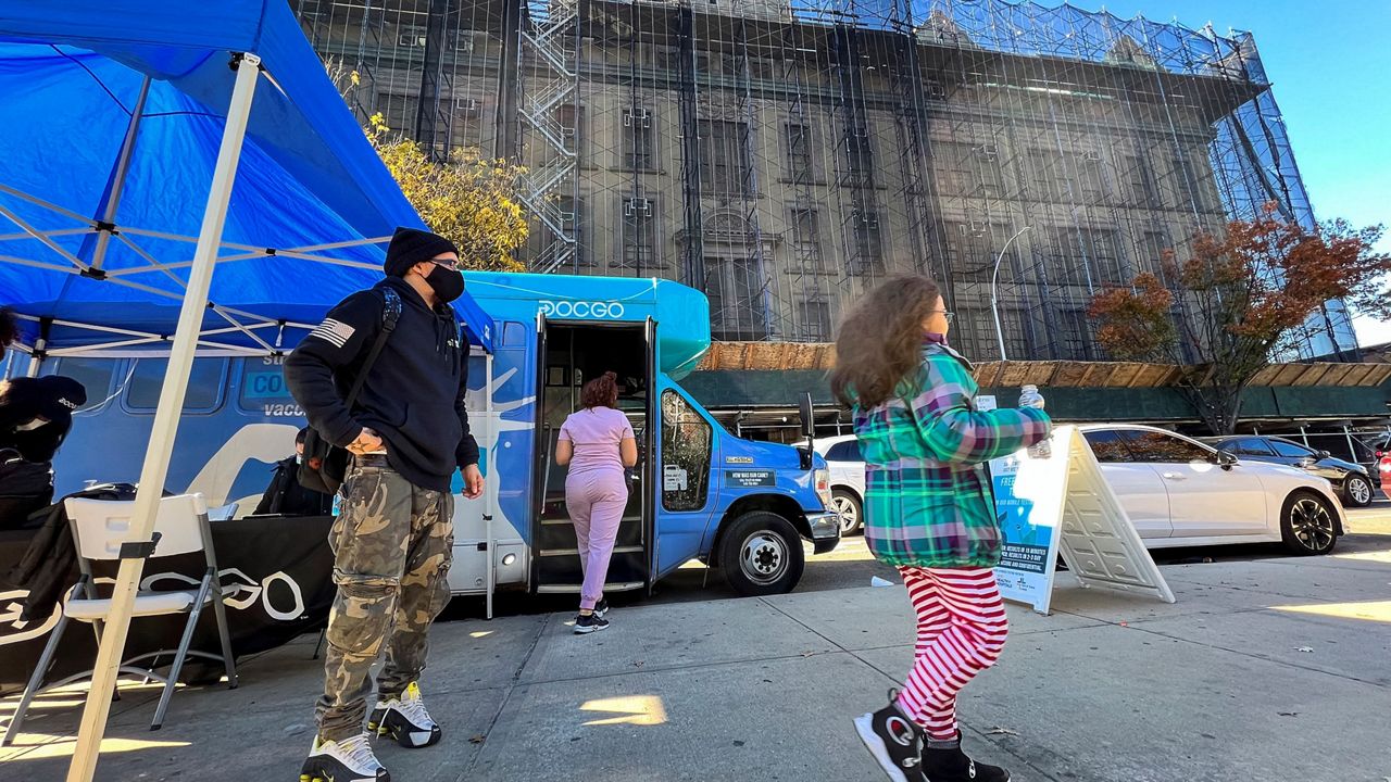 A girl walks outside of a mobile vaccine unit after getting the first dose of her COVID-19 vaccine, outside P.S. 277, Friday, Nov. 5, 2021, in the Bronx borough of New York. (AP Photo/Eduardo Munoz Alvarez)