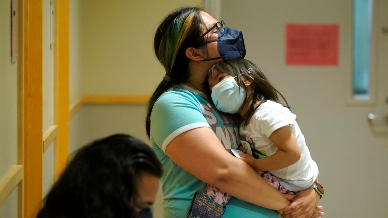 Deni Valenzuela, 2, is held by her mother, Xihuitl Mendoza, in a waiting area after Deni was given a Pfizer COVID-19 vaccine shot on June 21, 2022, at a University of Washington Medical Center in Seattle. (AP Photo/Ted S. Warren, File)