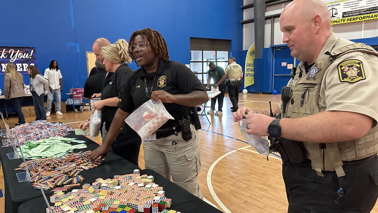 Officers line up to build their kit, stuffing it with items that distract a child during a crisis