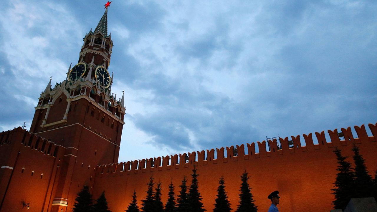 A guard patrols in front of the walls of the Kremlin at dusk in Red Square on June 30, 2018. (AP Photo/Rebecca Blackwell, File)