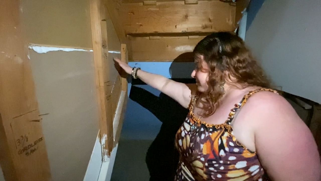 Lauren Gomez examines the damage in her basement one year after Hurricane Ida. (NY1 Photo)