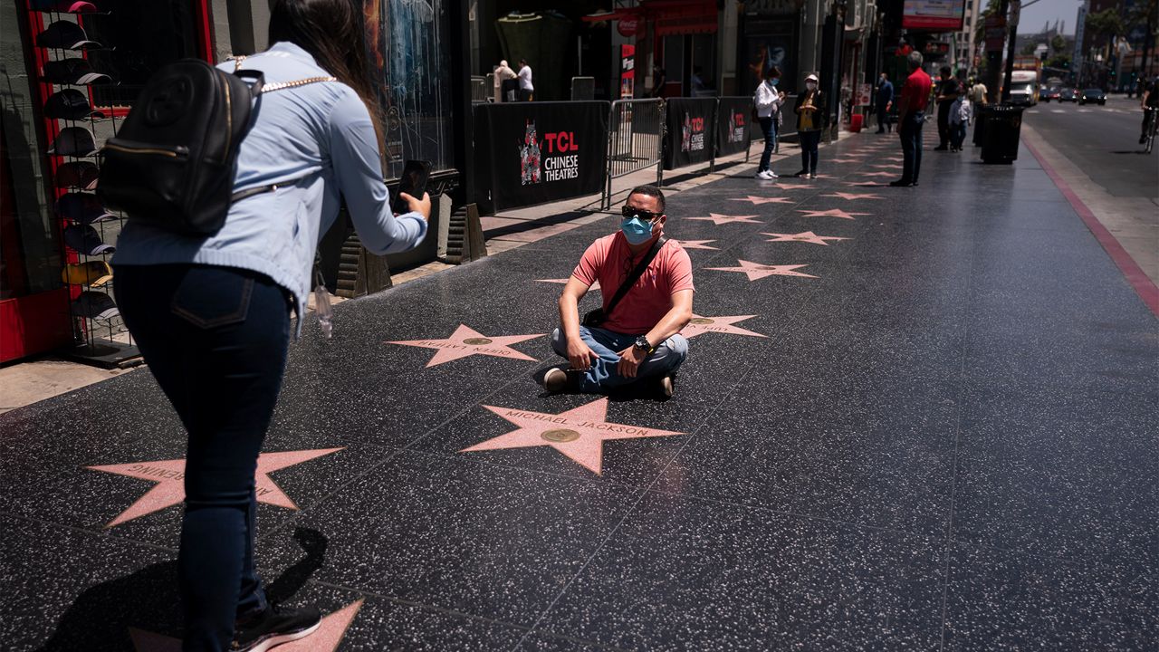 A tourist sits on the Hollywood Walk of Fame in the Hollywood section of Los Angeles, May 3, 2021. (AP Photo/Jae C. Hong)